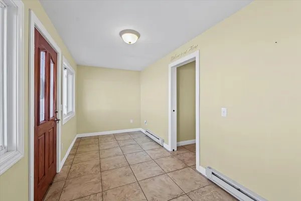 a view of a hallway with wooden floor and a bathroom