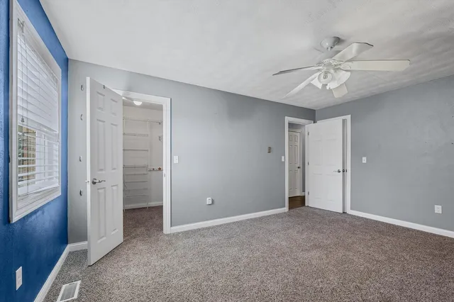 an empty room with closet and windows