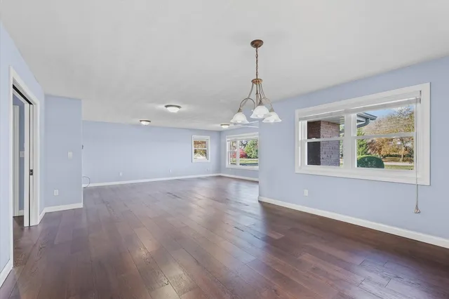 a view of a room with wooden floor chandelier and window