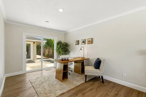 a view of a work space with wooden floor and windows
