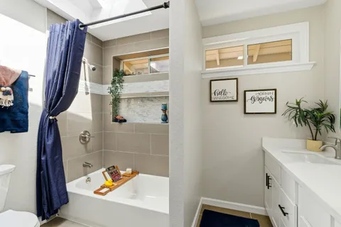 a bathroom with a sink a toilet a shower curtain and a bath tub