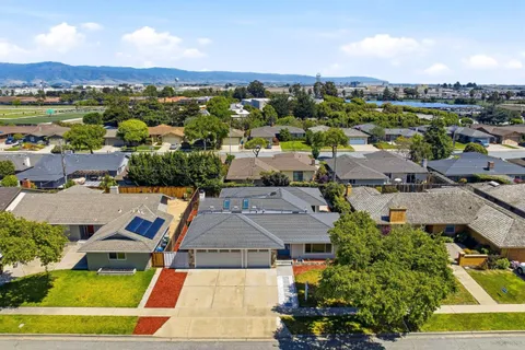 an aerial view of residential houses with outdoor space and ocean view
