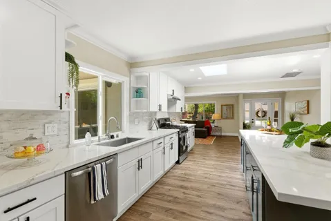 a large kitchen with kitchen island a stove a sink a dining table and chairs