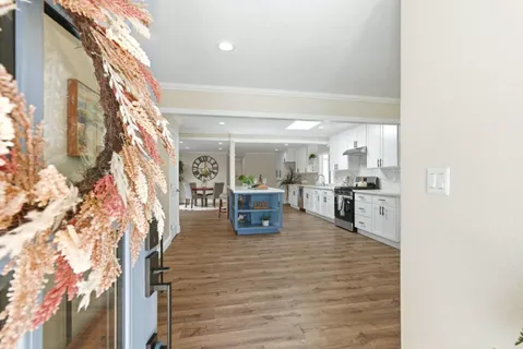 a room with stainless steel appliances kitchen island granite countertop a refrigerator and a sink