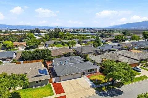 an aerial view of a city with lots of residential buildings and mountain view in back
