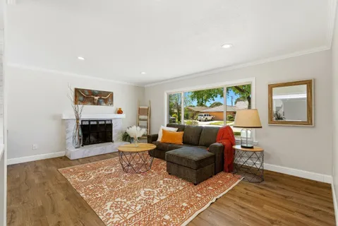 a living room with fireplace furniture and a wooden floor