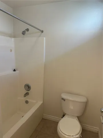 a white toilet sitting next to a bath tub