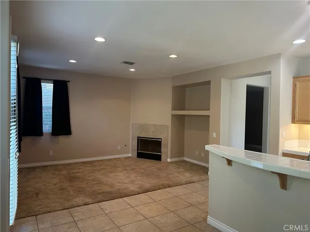 a view of an empty room with a fireplace and a window