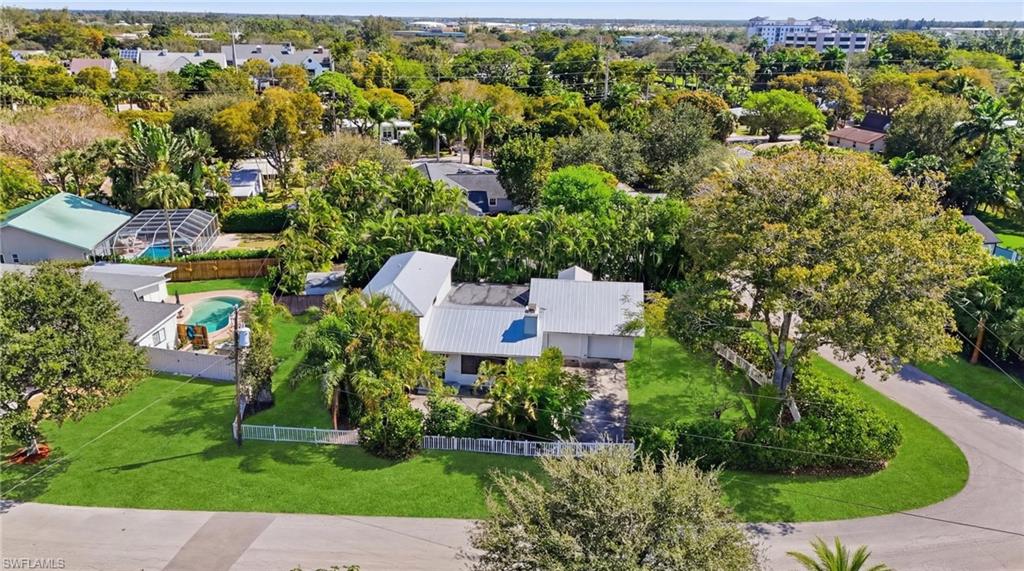 an aerial view of residential house with outdoor space and trees all around