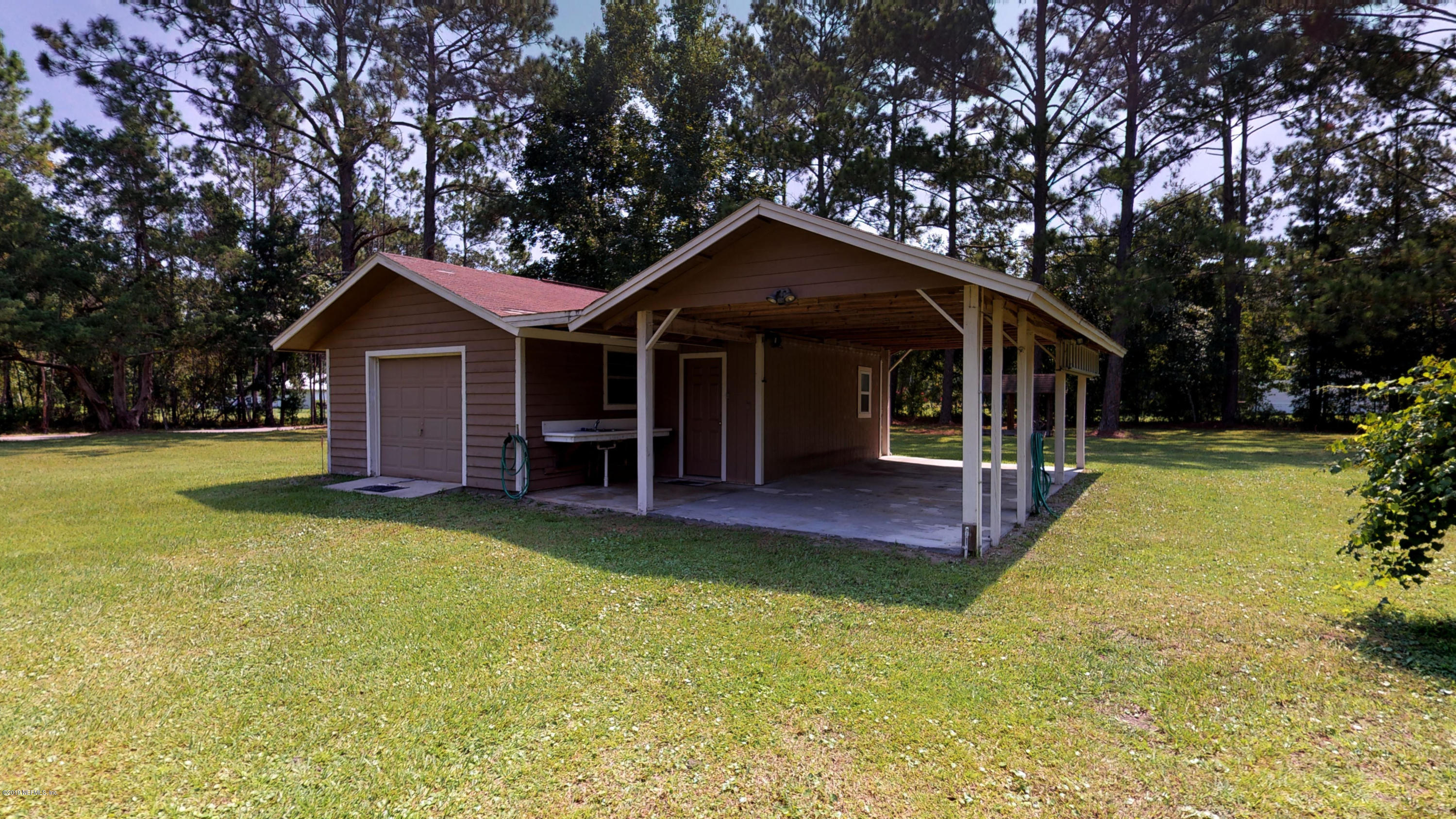 5175 Scaff Road St. Augustine, FL 32092 - Photo 7 of 20 a porch with a table and chairs under an umbrella