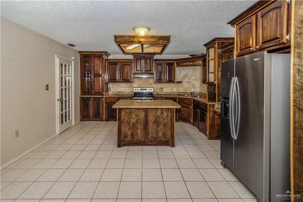 a kitchen with stainless steel appliances granite countertop a refrigerator and a stove
