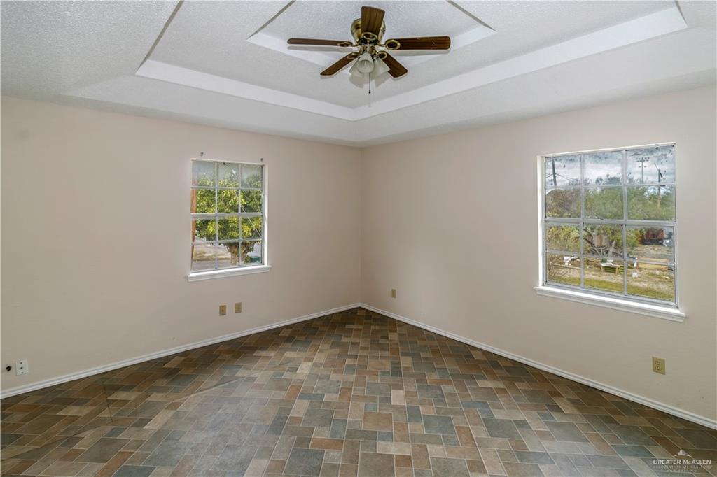 207 East Saenz Avenue Pharr, TX 78577 - Photo 18 of 21 an empty room with windows and ceiling fan