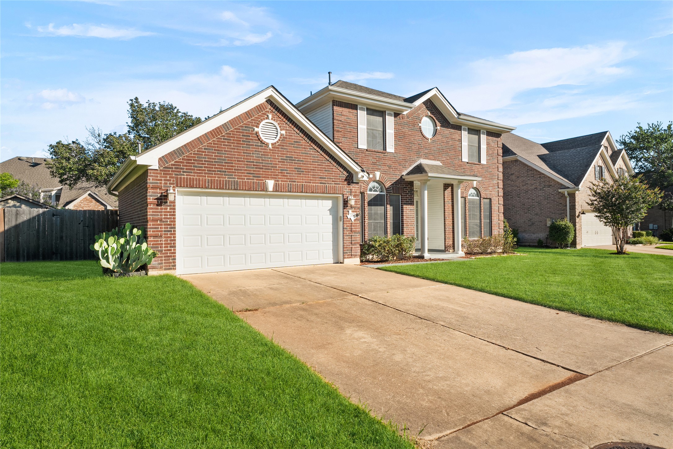 206 River Down Road Georgetown, TX 78628 - Photo 2 of 39 Brick facade residence featuring an attached two-car garage, concrete driveway, and front entryway with covered porch