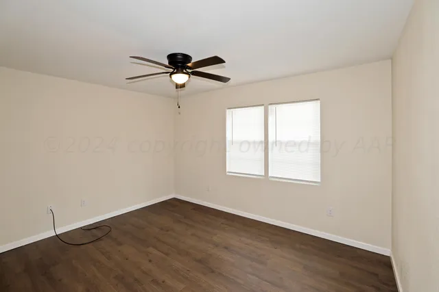 a view of a room with wooden floor and fan