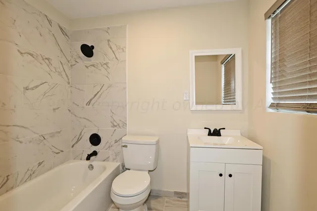 a white toilet sitting next to a bath tub