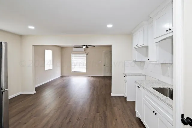 a view of a kitchen with wooden floor and electronic appliances