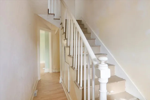 a view of staircase with railing and white walls