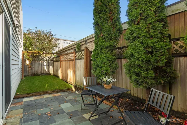 a view of a patio with table and chairs and potted plants with wooden fence