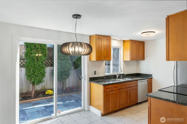 a kitchen with stainless steel appliances granite countertop a sink a stove and a wooden floors