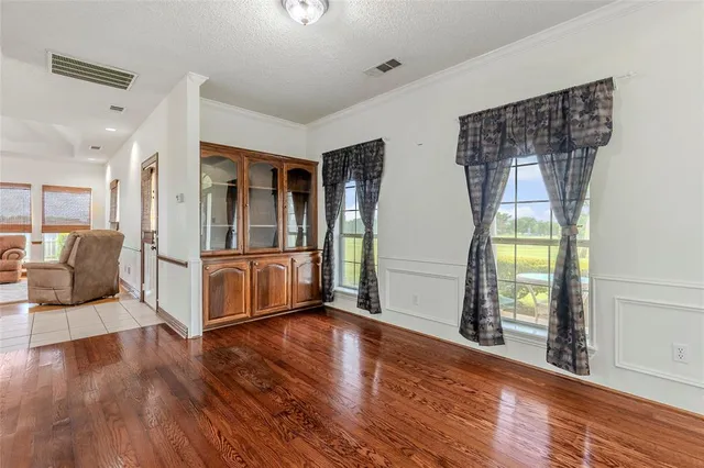 a living room with stainless steel appliances wooden floor and a window