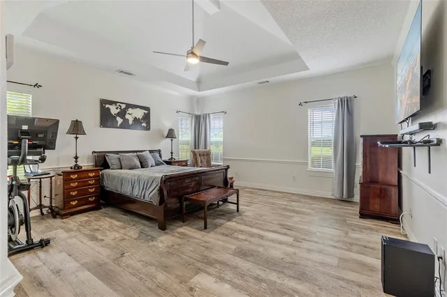 a spacious bedroom with a bed and a flat screen tv