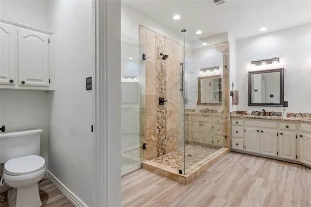 a bathroom with a double vanity sink toilet and shower