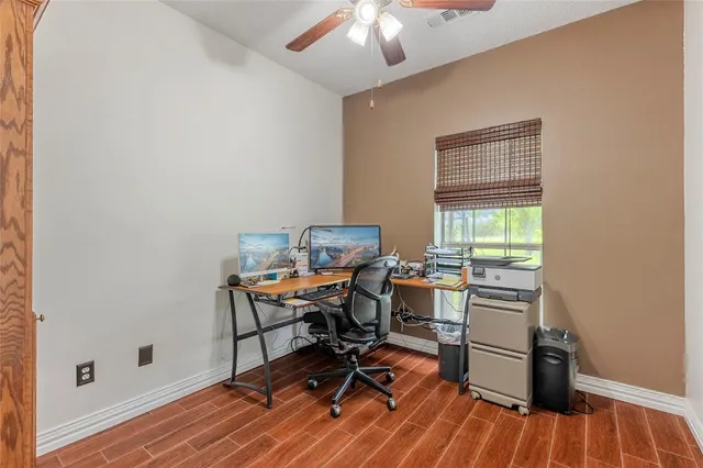 a view of a workspace with furniture and a window