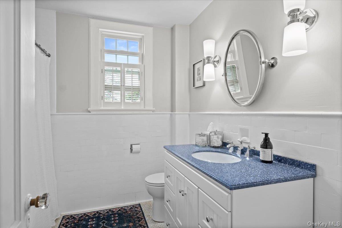 400 Manor Ridge Road Pelham, NY 10803 - Photo 30 of 39 a bathroom with a granite countertop sink a toilet and a mirror