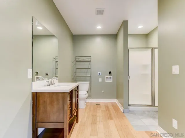 a spacious bathroom with a double vanity sink a mirror and a shower
