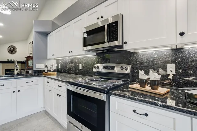 a kitchen with stainless steel appliances granite countertop a sink a stove and microwave
