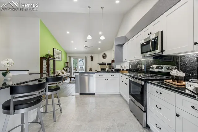 a kitchen with stainless steel appliances kitchen island granite countertop a sink and cabinets
