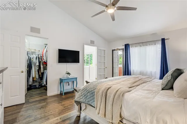 a bedroom with a bed and a flat tv screen on wall