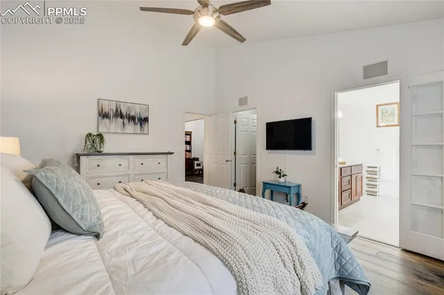 a bedroom with a bed and a flat tv screen on dresser