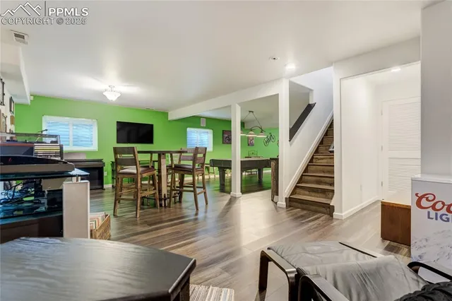 a dining room with furniture entryway and wooden floor