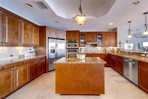 a kitchen with stainless steel appliances granite countertop a stove a sink and a wooden floors