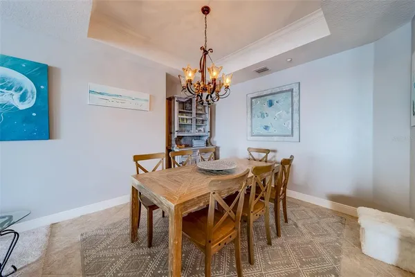 a living room with furniture a chandelier fan and a large window