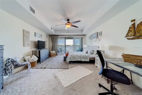 a bedroom with a large bed and a flat tv screen on dresser