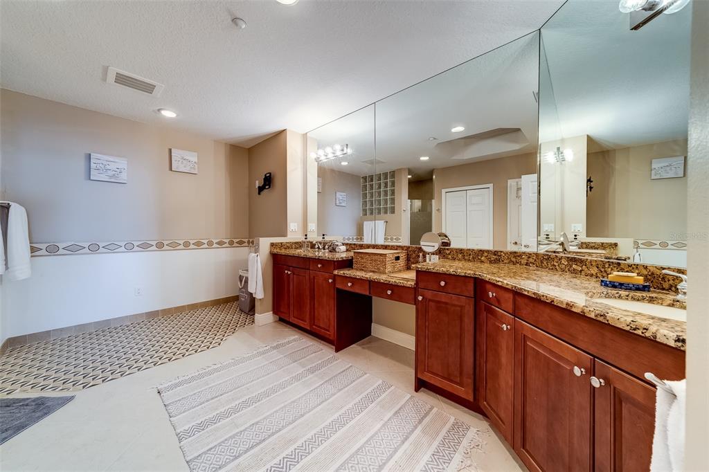 17745 Gulf Boulevard, Unit 303 Redington Shores, FL 33708 - Photo 34 of 83 a large kitchen with stainless steel appliances kitchen island granite countertop a large counter top a sink a stove and a wooden floors