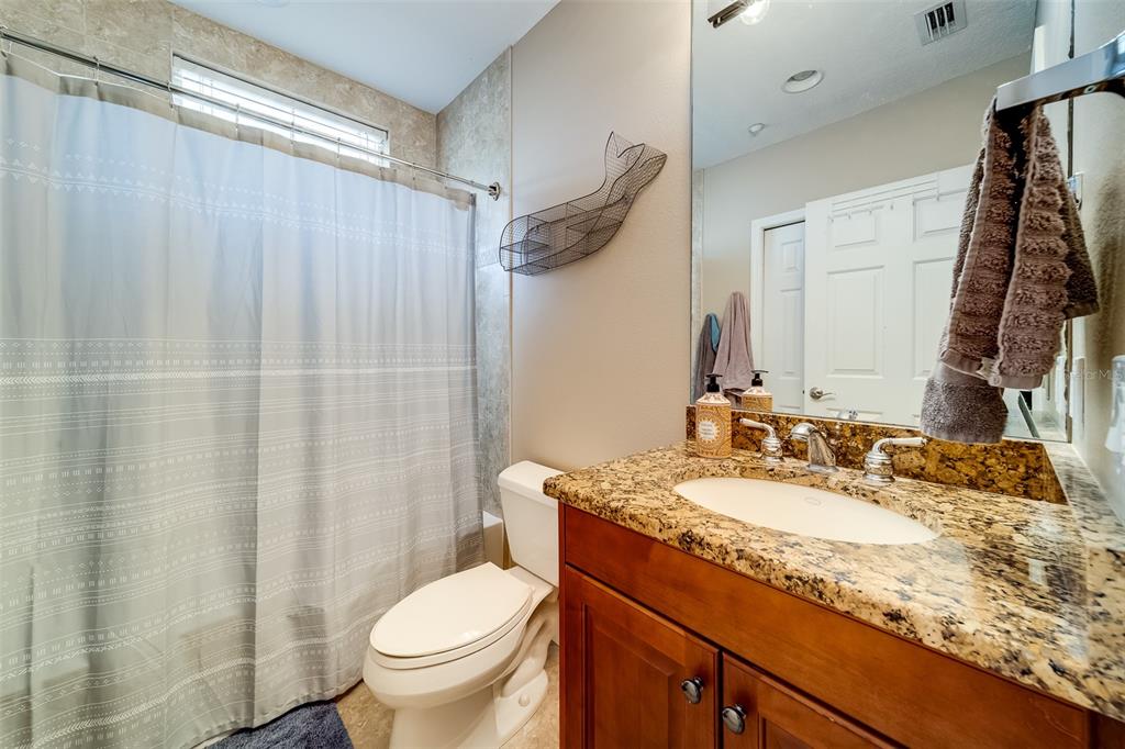 17745 Gulf Boulevard, Unit 303 Redington Shores, FL 33708 - Photo 44 of 83 a bathroom with a granite countertop sink toilet and a mirror