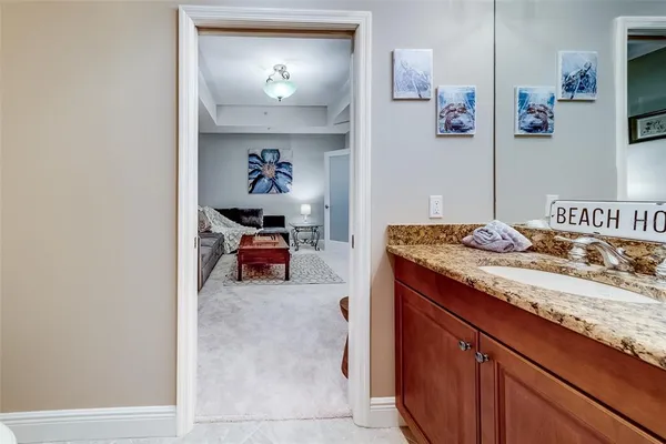 a en suite bathroom with a granite countertop sink a toilet and a mirror