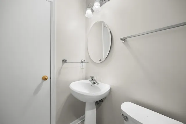 a bathroom with a sink a toilet and a mirror