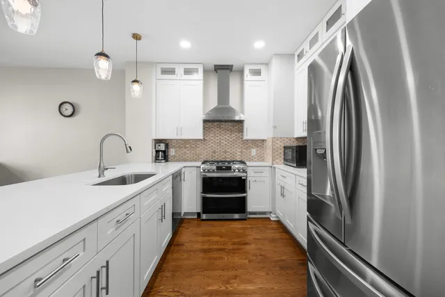 a kitchen with stainless steel appliances granite countertop a sink and a stove top oven