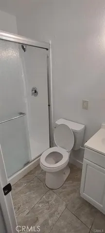 a white toilet sitting next to a shower