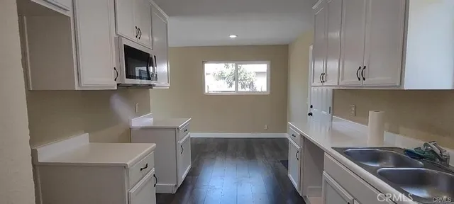 a kitchen with cabinets and wooden floor
