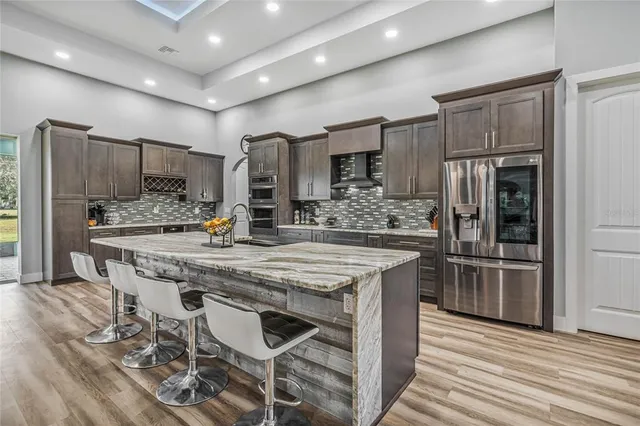 a kitchen with stainless steel appliances kitchen island granite countertop a stove microwave and refrigerator