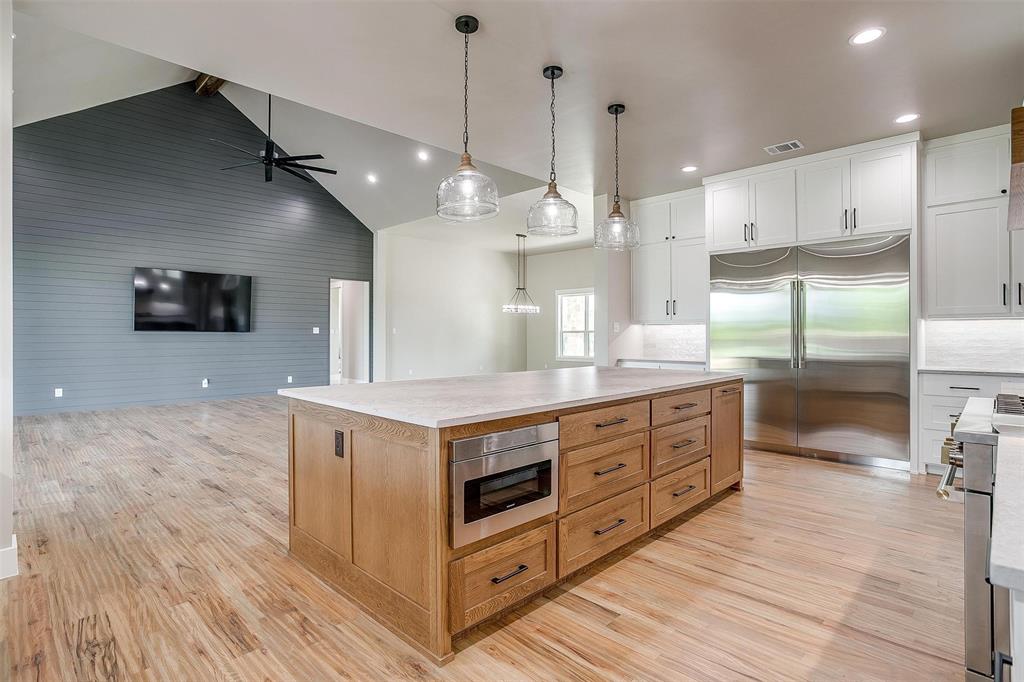 3019 Orchard Road Bowie, TX 76230 - Photo 40 of 40 a large kitchen with stainless steel appliances a large counter top a stove a chimney a sink and a large window