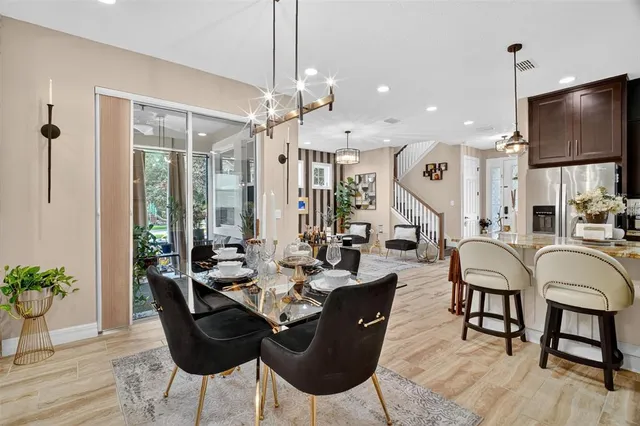 a living room with furniture kitchen view and a wooden floor