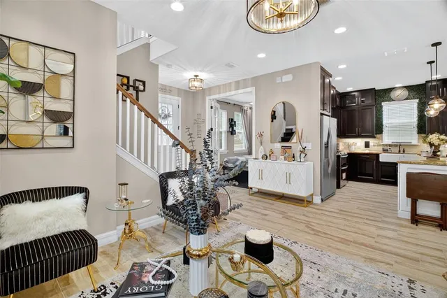 a view of a livingroom with furniture stairs wooden floor and windows