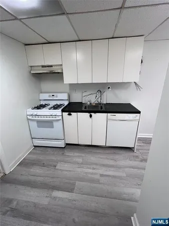 a kitchen with granite countertop white cabinets and white stainless steel appliances