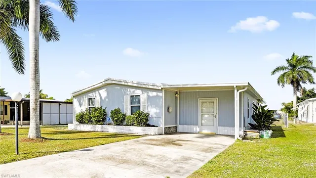 a view of a house with a swimming pool and a lawn chairs with palm trees